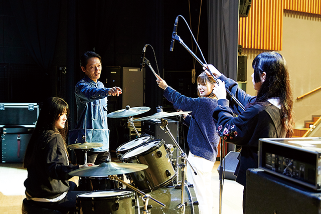 ステージ設営の演習を行う、先生と学生たちの様子