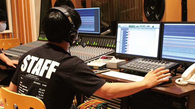 レコーディングスタジオで機材操作をする学生