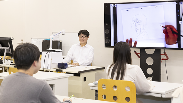 手元カメラから写された先生の描き方を見る学生たちの写真
